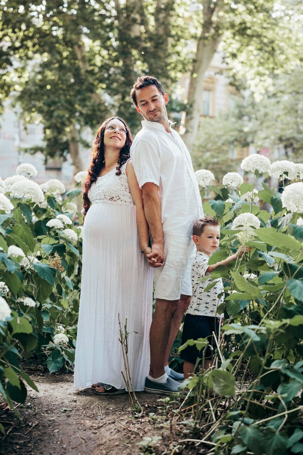 Trudnica u prirodi nježno gleda prema trbuhu dok je obasjava toplo svjetlo