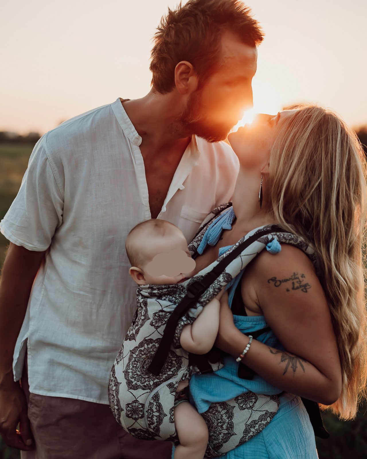 Obitelj promatra zalazak sunca na livadi